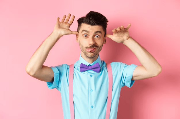 Een volwassen man trekt een kinderachtig gezicht en steekt speels zijn tong uit, wat het contrast toont tussen fysieke volwassenheid en het ontbreken van emotionele volwassenheid.